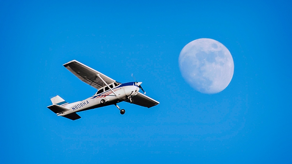 A Cessna 172 airplane flies Sunday, Jan. 12, 2014 over a nearly full moon as it leaves the Bowling Green/Warren County Regional Airport in Bowling Green, Ky. (AP Photo/Daily News, Joshua Lindsey)