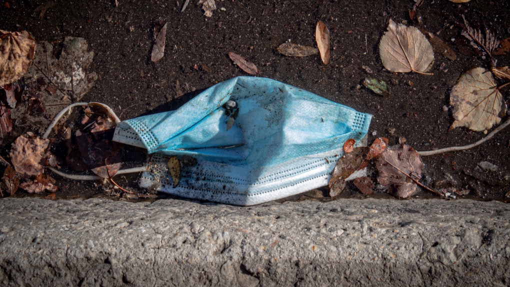 A discarded mask litters the street. (Photo by Elizabeth McDaniel on Unsplash)