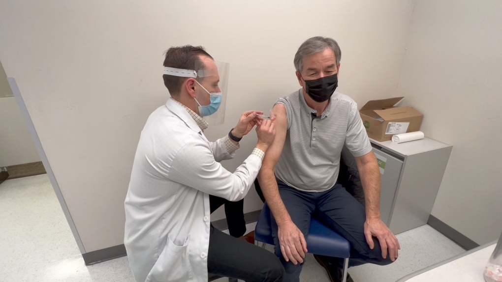 Ottawa pharmacist Jordan Clark administers a vaccine to a customer. (Dave Charbonneau/CTV News Ottawa)