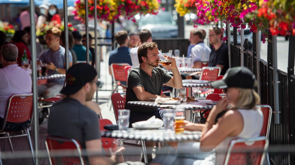 A patron drinks a beverage at a patio in the Byward Market in Ottawa, as patios open in Ontario's first phase of re-opening amidst the third wave of the COVID-19 pandemic, on Saturday, June 12, 2021. THE CANADIAN PRESS/Justin Tang 
