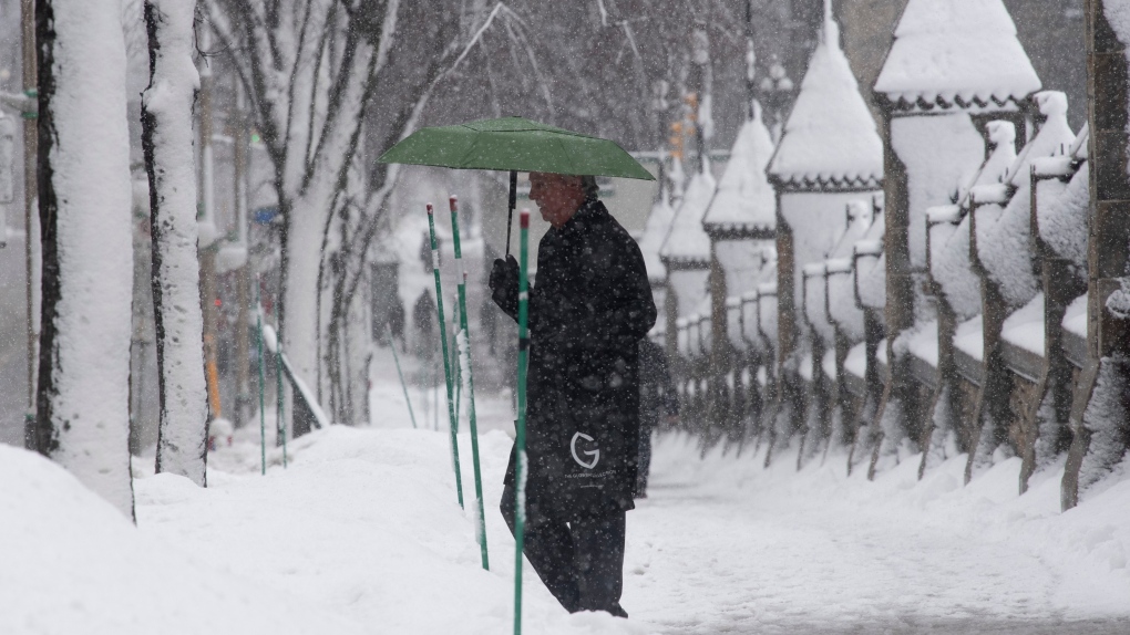 A man walks along the side walk near Parliament Hill during a snow storm in Ottawa, Thursday, Feb. 27, 2020. THE CANADIAN PRESS/Adrian Wyld 