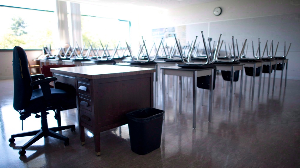 A empty teacher's desk is pictured in an empty classroom at Mcgee Secondary school in Vancouver on Sept. 5, 2014. A major union representing education workers in Ontario says its members have voted overwhelmingly in favour of a potential strike that could take effect by the end of the month. THE CANADIAN PRESS/Jonathan Hayward