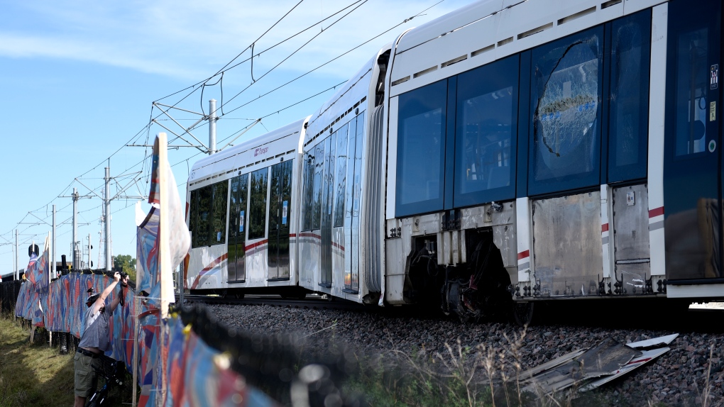 A window is broken and the wheels of a segment of an OC Transpo O-Train is seen west of Tremblay LRT Station in Ottawa on Monday, Sept. 20, 2021 after it derailed on Sunday. (Justin Tang/THE CANADIAN PRESS)