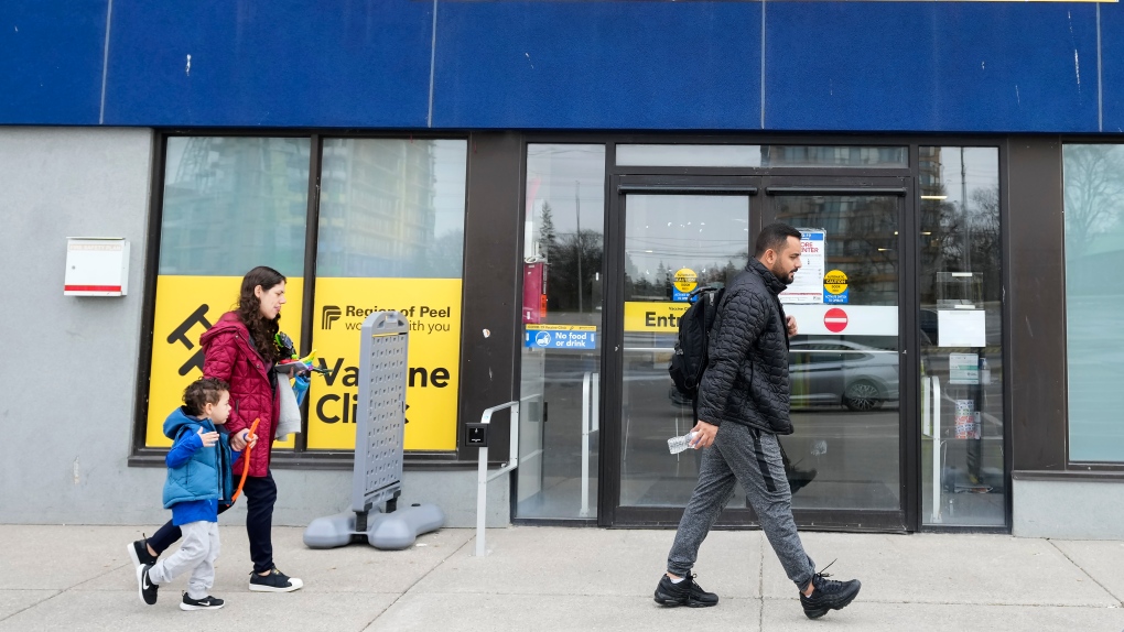 People walk past a vaccine clinic during the COVID-19 pandemic in Mississauga, Ont., on Wednesday, April 13, 2022. THE CANADIAN PRESS/Nathan Denette