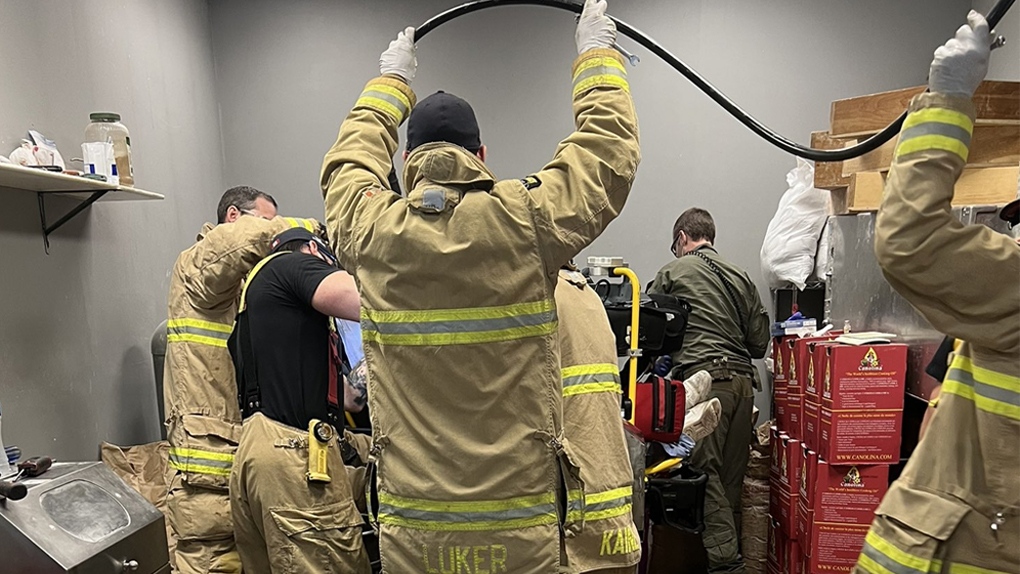 Firefighters work to free a man's hand from a bread-making machine at a business in Orleans. (Ottawa Fire Service/Twitter) 
