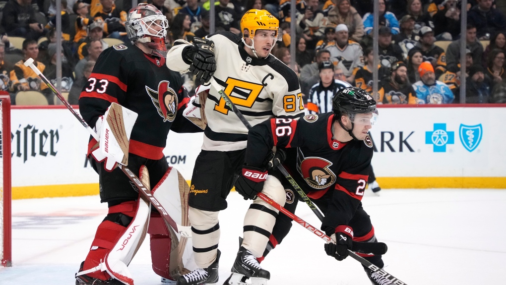 Pittsburgh Penguins' Sidney Crosby (87) screens Ottawa Senators goaltender Cam Talbot (33) with Erik Brannstrom (26) defending during the second period of an NHL hockey game in Pittsburgh, Friday, Jan. 20, 2023. (AP Photo/Gene J. Puskar)