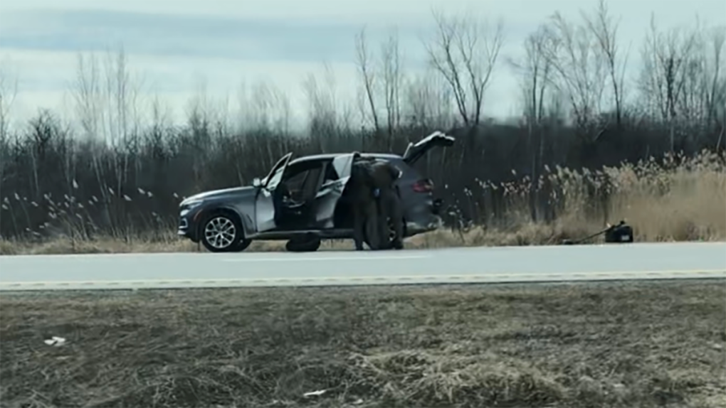Police officers search a vehicle on Highway 401 eastbound near Cornwall, Ont. April 11, 2023. Eastbound lanes of the highway are closed for a police investigation. (Nate Vandermeer/CTV News Ottawa)