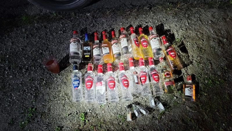 Alcohol bottles allegedly found in a vehicle being driven by someone who blew 3 times the legal limit on Highway 416 May 28, 2023, according to OPP. (OPP/Twitter)
