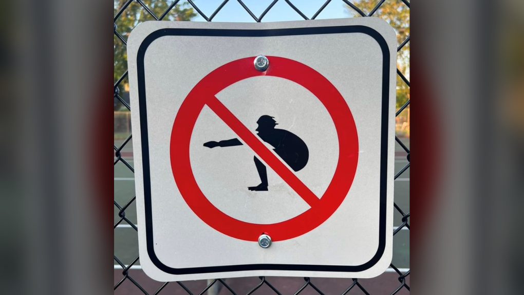 A sign showing an individual in a squat position with the prohibition sign over the image appeared on the fence at St. Luke's Park. The city says it did not post the sign. (Ariel Troster/X)