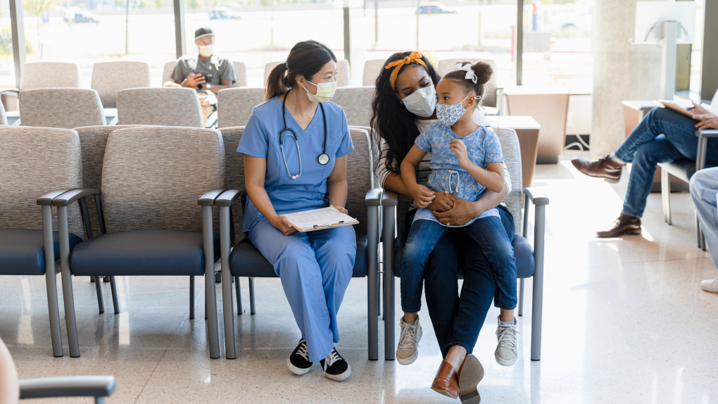 A doctor and patients wear face masks in a hospital waiting room. (Getty Images)